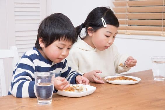 Enfant mangeant du riz au curry à la maison.