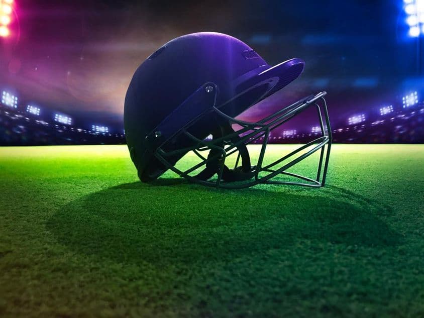 Casque de cricket vu de dessous sur de l'herbe verte.