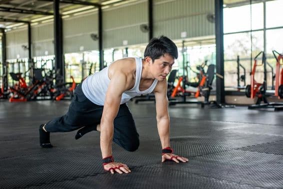 Homme à la salle de sport levant la jambe et bougeant