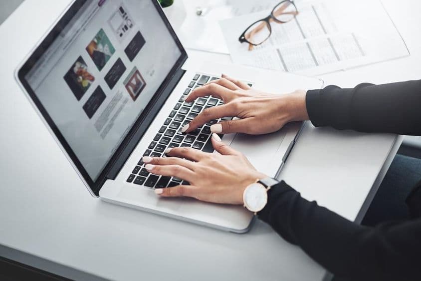 Femme travaillant à distance depuis chez elle avec un ordinateur portable.