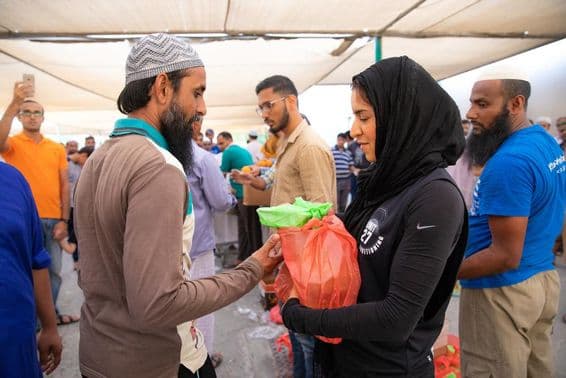 Bénévoles distribuant des colis alimentaires aux travailleurs lors de l'iftar.