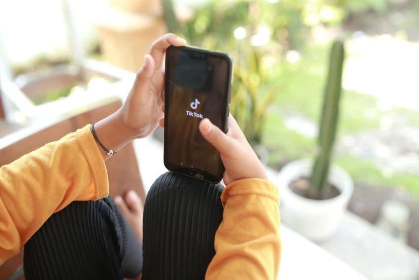 Un enfant regardant du contenu TikTok sur un téléphone portable.