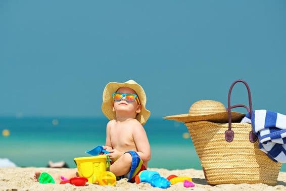 Garçon de deux ans jouant sur la plage.