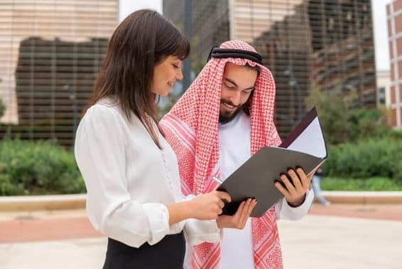 Femme d'affaires discutant des détails du contrat avec un client arabe.