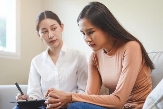 Jeune femme asiatique triste consultant un psychologue.