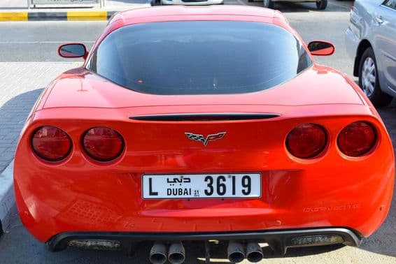 Chevrolet Corvette rouge avec plaque d'immatriculation de Dubai.