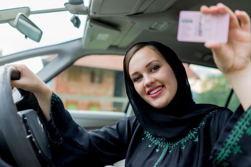 Femme musulmane heureuse conduisant une voiture.