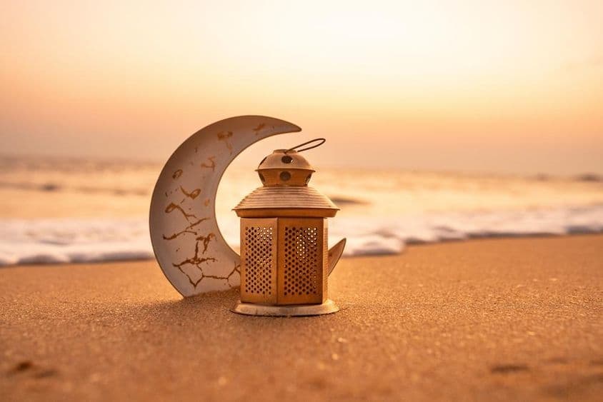 Croissant de lune traditionnel éclairé par des bougies sur la plage.