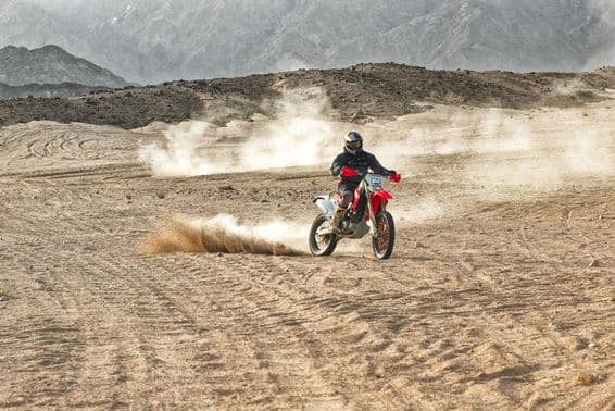 Motard portant un casque roulant dans le désert