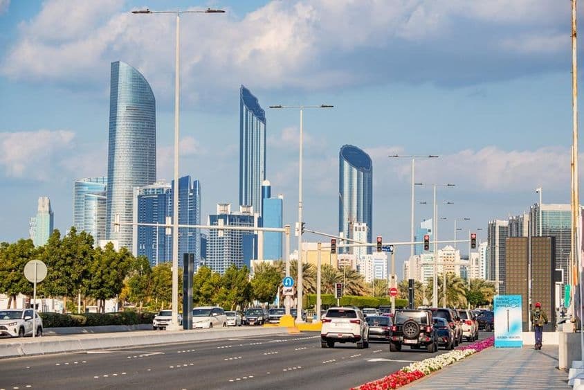 Abu Dhabi, gratte-ciels modernes se dressant en arrière-plan de la route fréquentée de Corniche.
