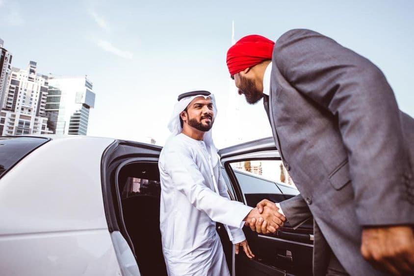Homme d'affaires arabo-indien discutant des plans futurs à Dubaï dans une limousine.