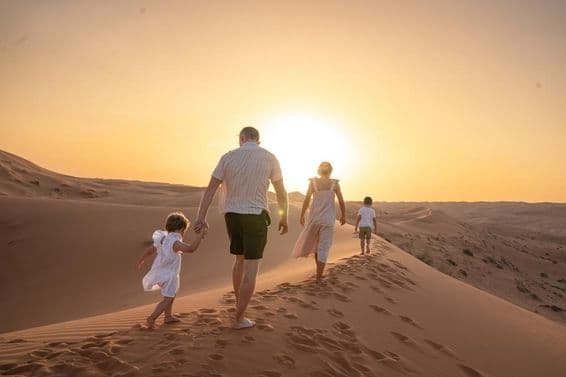 Famille profitant du coucher de soleil dans le désert.