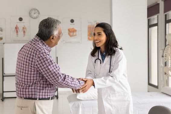 Jeune femme médecin souriante examinant un patient.