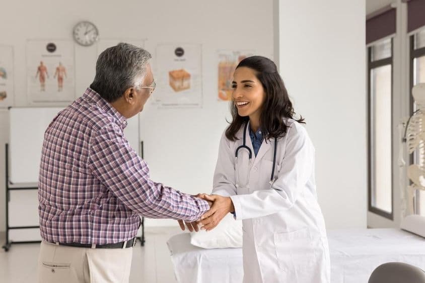 Jeune femme médecin souriante examinant un patient.
