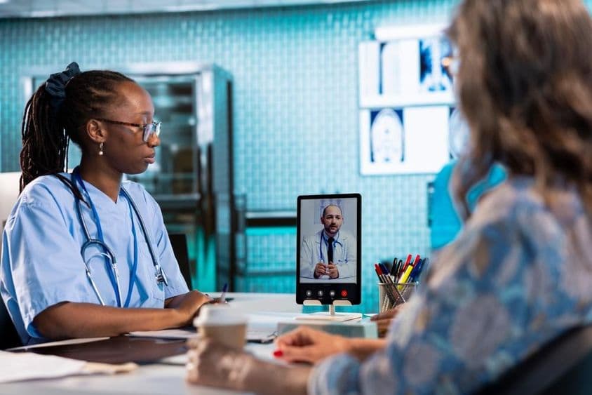 Infirmière ayant un appel vidéo avec un médecin pour une consultation à distance et la télémédecine.