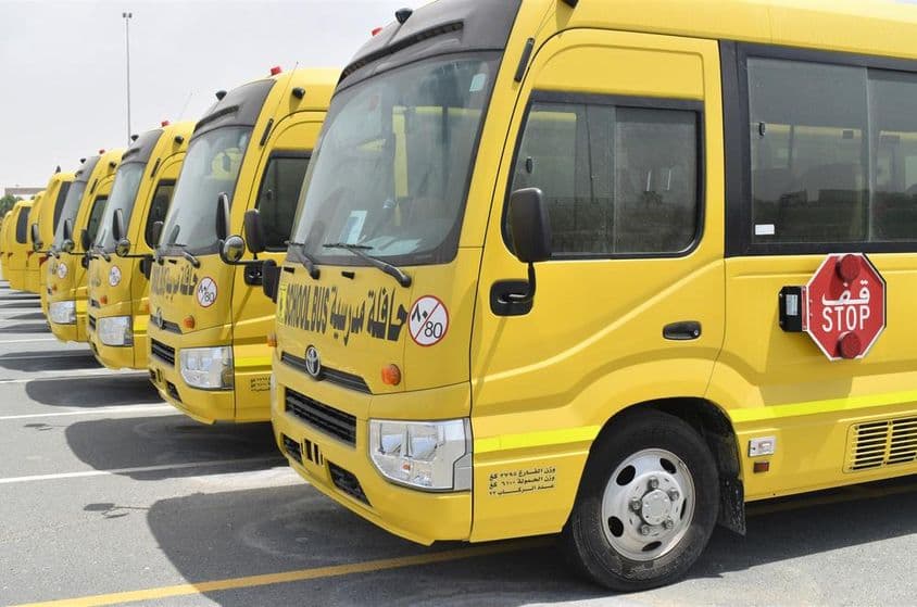 Bus scolaires jaunes alignés dans un parking à Dubaï.