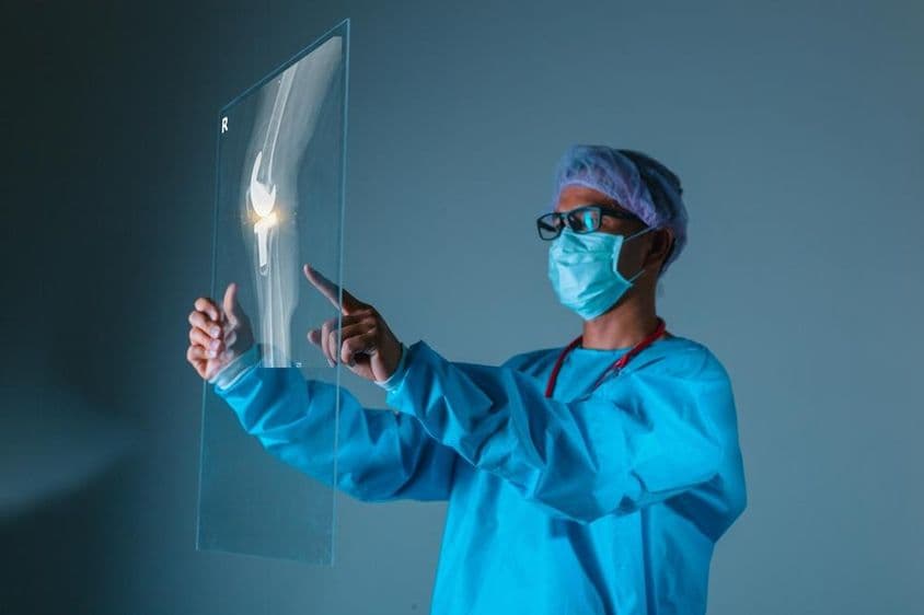 Médecin tenant une radio d'os du patient avant une intervention chirurgicale.