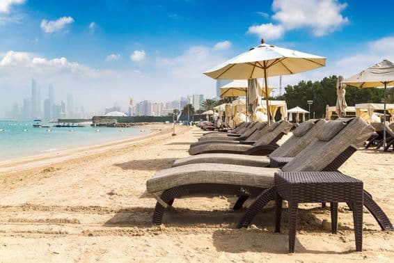 Chaises longues et parasols sur la plage à Abu Dhabi.