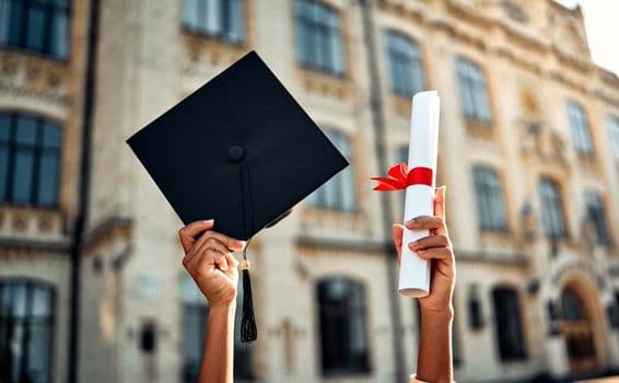 Chapeau de graduation et diplôme avec ruban rouge.