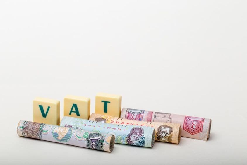 Les lettres TVA au-dessus de billets de dirhams des Émirats Arabes Unis.
