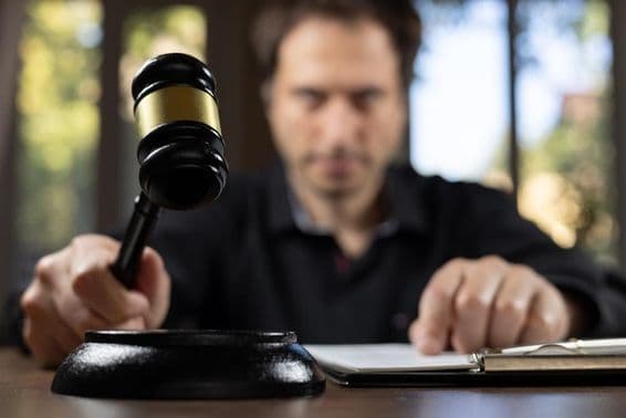 Un juge tenant un marteau de justice signalant la fin d'un procès.