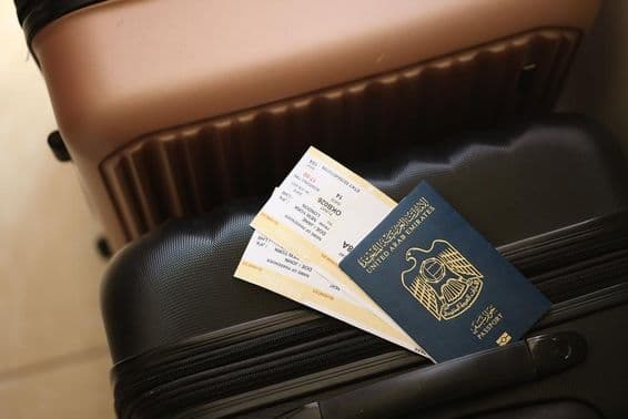 Émirats Arabes Unis, passeport avec des billets sur une valise.