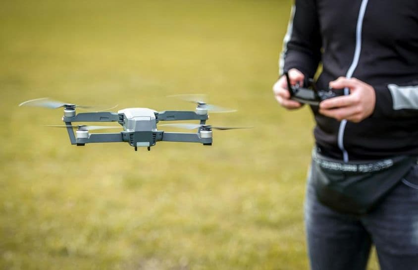 Un homme contrôlant un drone avec une télécommande.