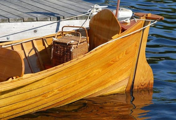 Bateau ancien avec panier de pique-nique à la poupe.