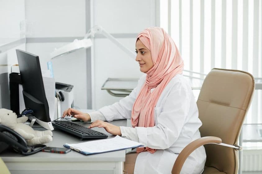 Jeune femme moyen-orientale portant un hijab travaillant comme infirmière dans une clinique médicale.