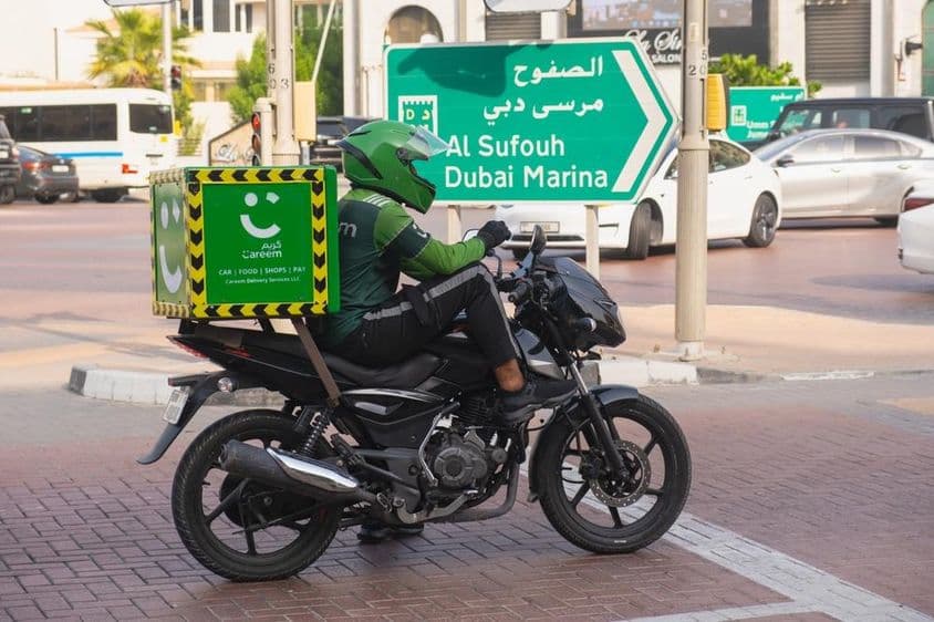 Coursier à moto du service de livraison vert Careem.