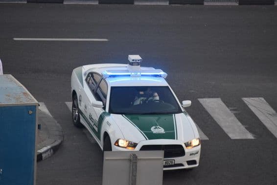 Une voiture de police de Dubaï circulant dans la rue.