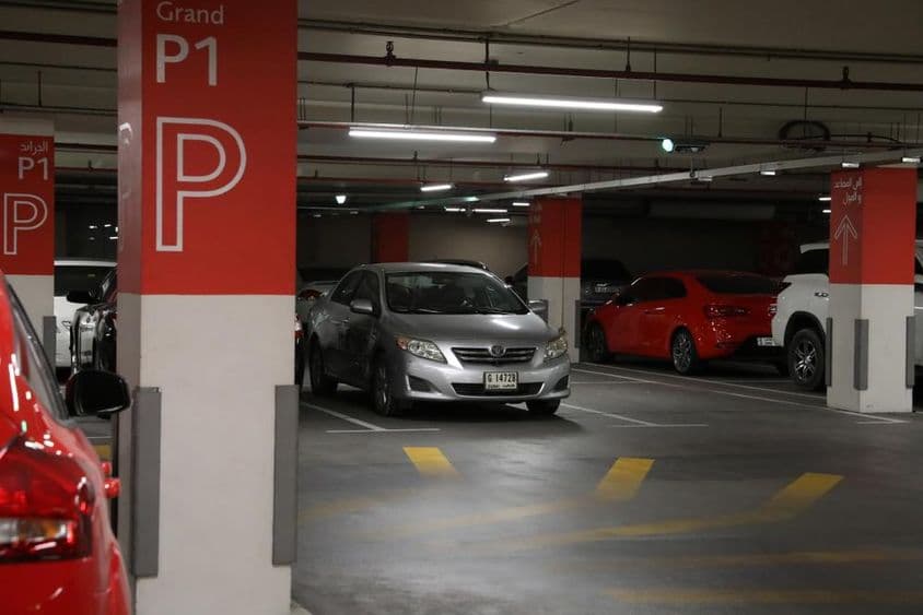 Parking souterrain moderne à Dubaï avec diverses voitures.