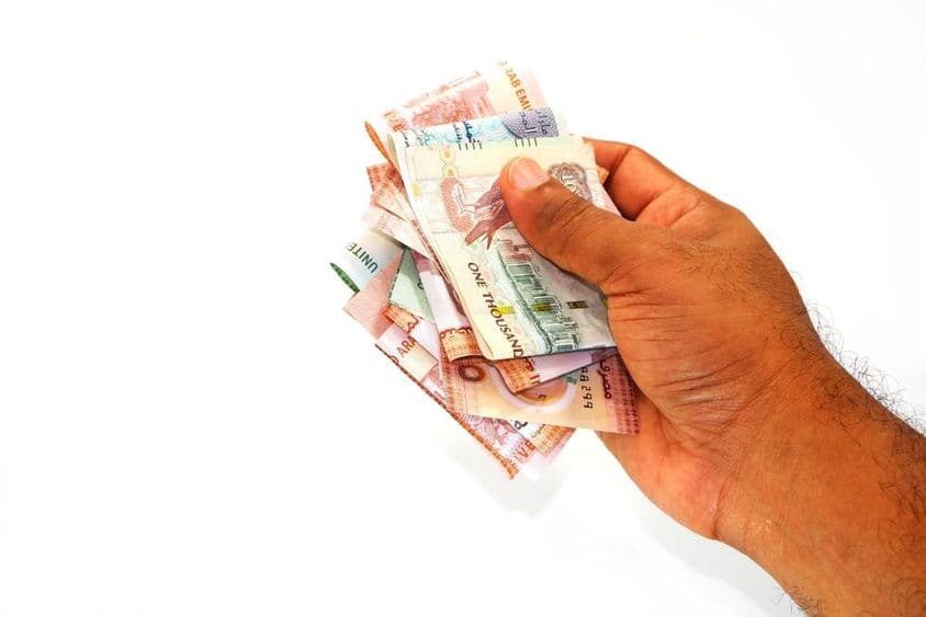 Billets de dirham tenus à la main.