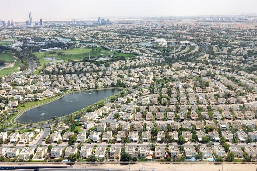 Emirates Hills Dubaï avec maisons communautaires, lac et verdure.