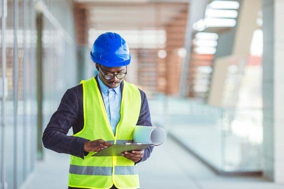 Jeune ingénieur civil analysant des statistiques sur papier.
