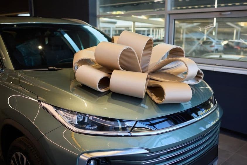 Voiture de prix décorée d'un ruban pour une occasion festive.
