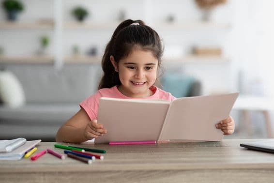Enfant du Moyen-Orient étudiant assis à un bureau à la maison.