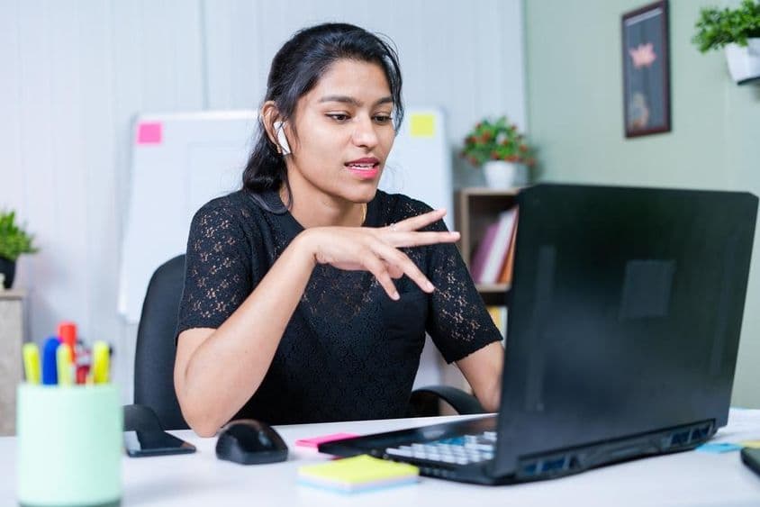 Jeune femme d'affaires indienne convaincant un client à propos d'un projet lors d'un appel vidéo.