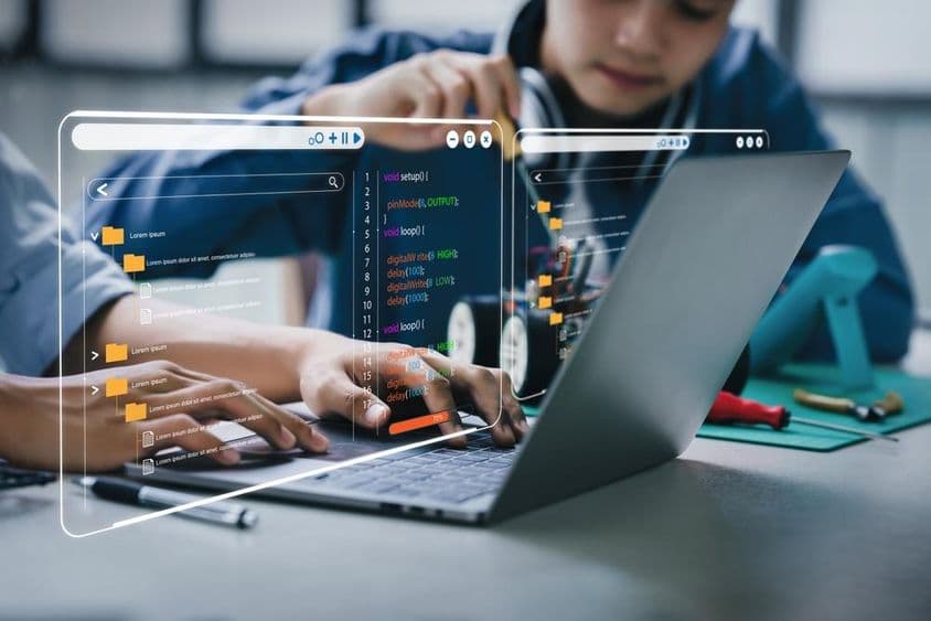 Étudiants asiatiques adolescents travaillant sur des devoirs liés aux bras robotiques et aux voitures robotisées.