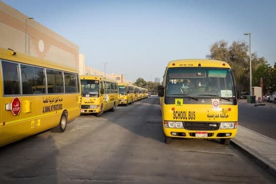 Bus scolaires jaunes alignés et garés à Abou Dhabi.