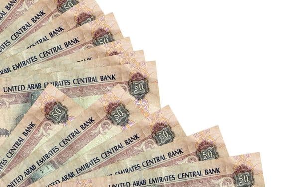 Billet de 50 dirhams des Émirats Arabes Unis posé sur une table.