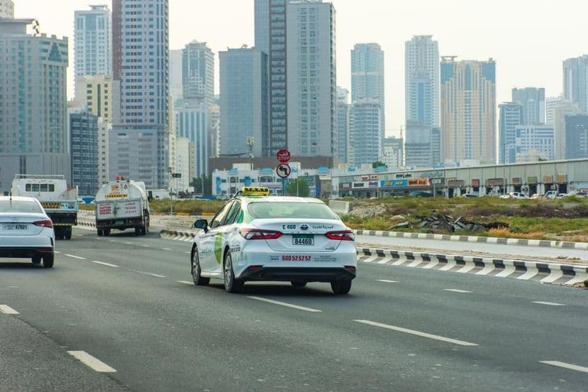 Aman taxi sur la route dans la ville de Sharjah.