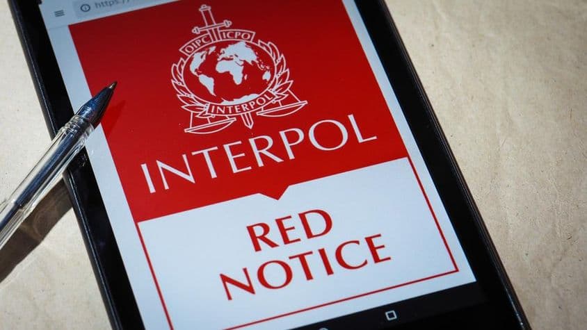 La notice rouge d'Interpol affichée sur l'écran d'un téléphone portable.