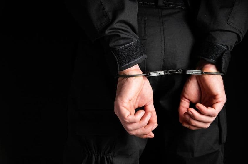 Les mains d'un criminel menotté.