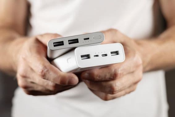 Deux batteries externes tenues à la main.