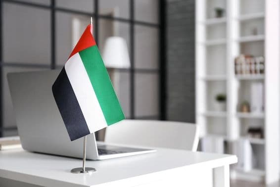 Drapeau des Émirats arabes unis sur une table dans un bureau moderne.
