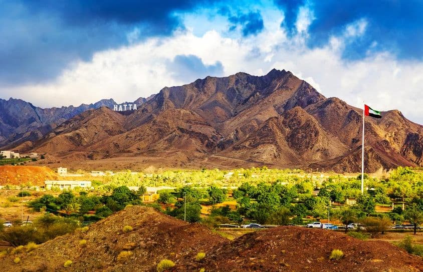 Panneau accueillant les visiteurs à la ville de Hatta dans les montagnes de Hajar.