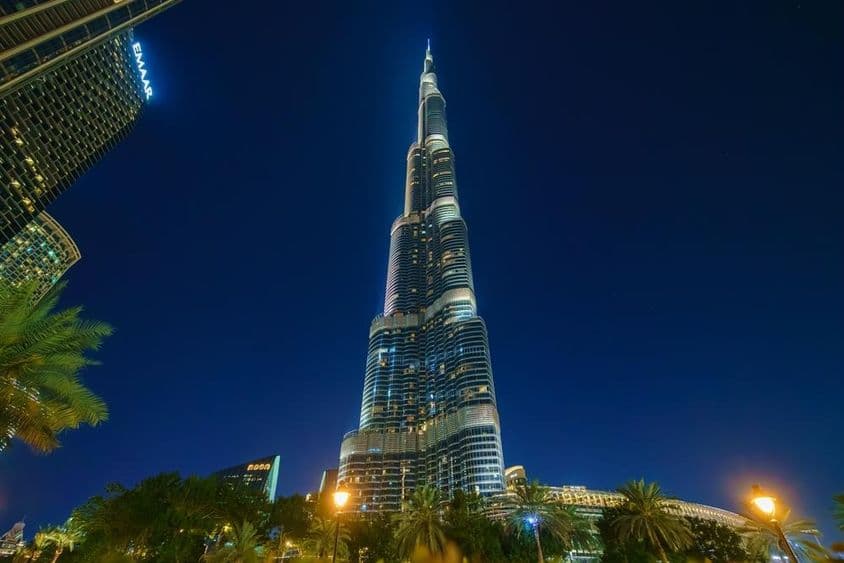 Vue panoramique de la tour Burj Khalifa depuis le sol, de nuit.