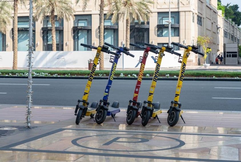 Image de trottinettes électriques orange à Dubaï.
