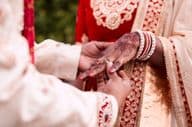 La main d'une mariée indienne recevant une bague.